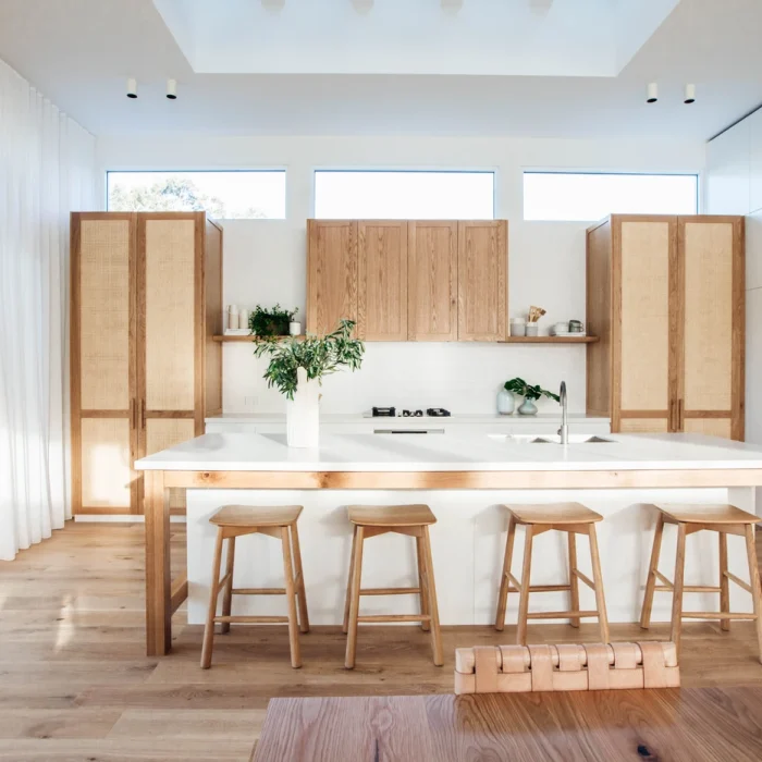 An open plan kitchen with timber cabinetry and timber joinery featuring a large island bench. | Shaker style Kitchen