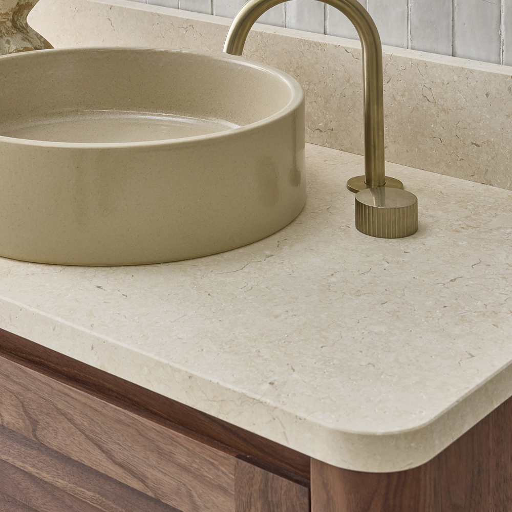 Limestone vanity top with gold tapwear